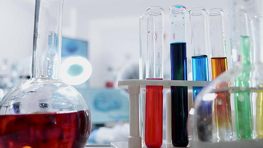 实验室中各种彩色液体管的第一个透视镜头靠近研究人员视频的预览图