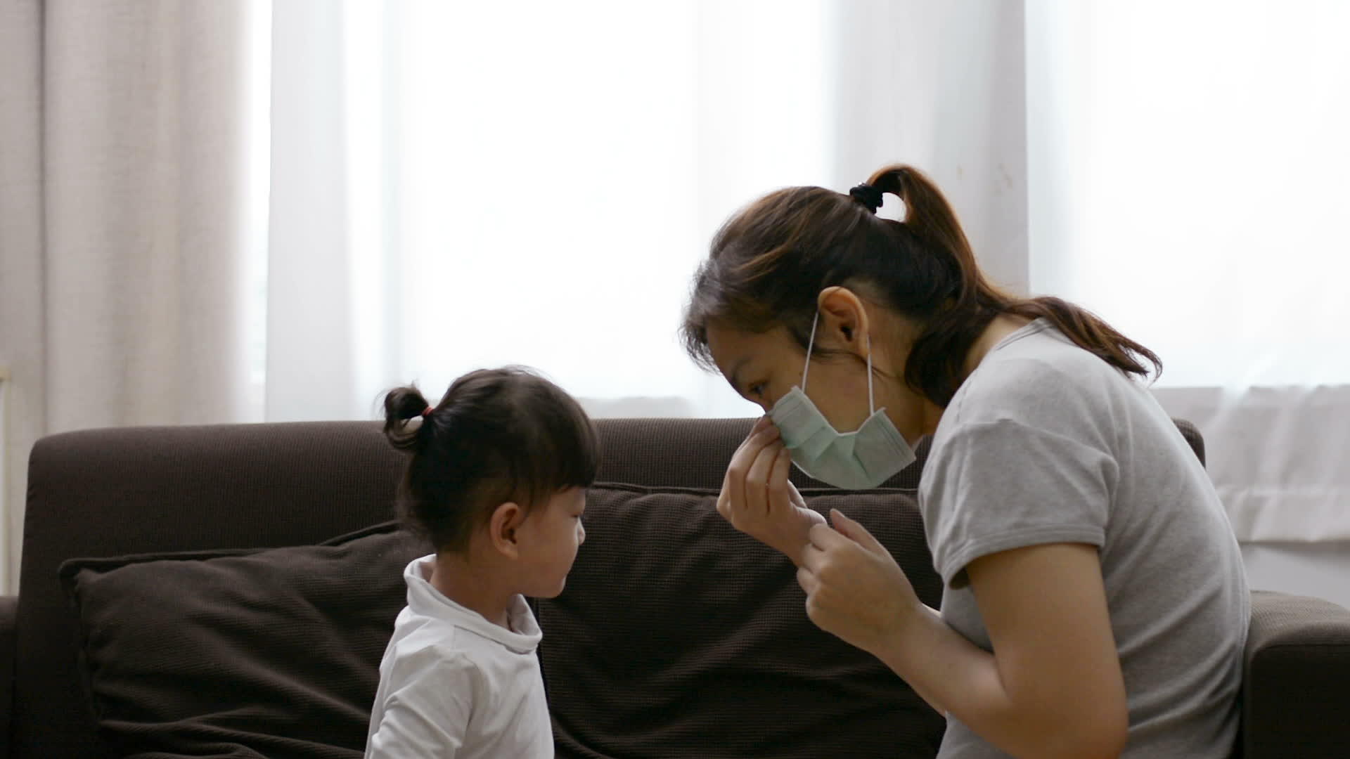 给女儿戴口罩以防止亚洲母亲穿衣服视频的预览图