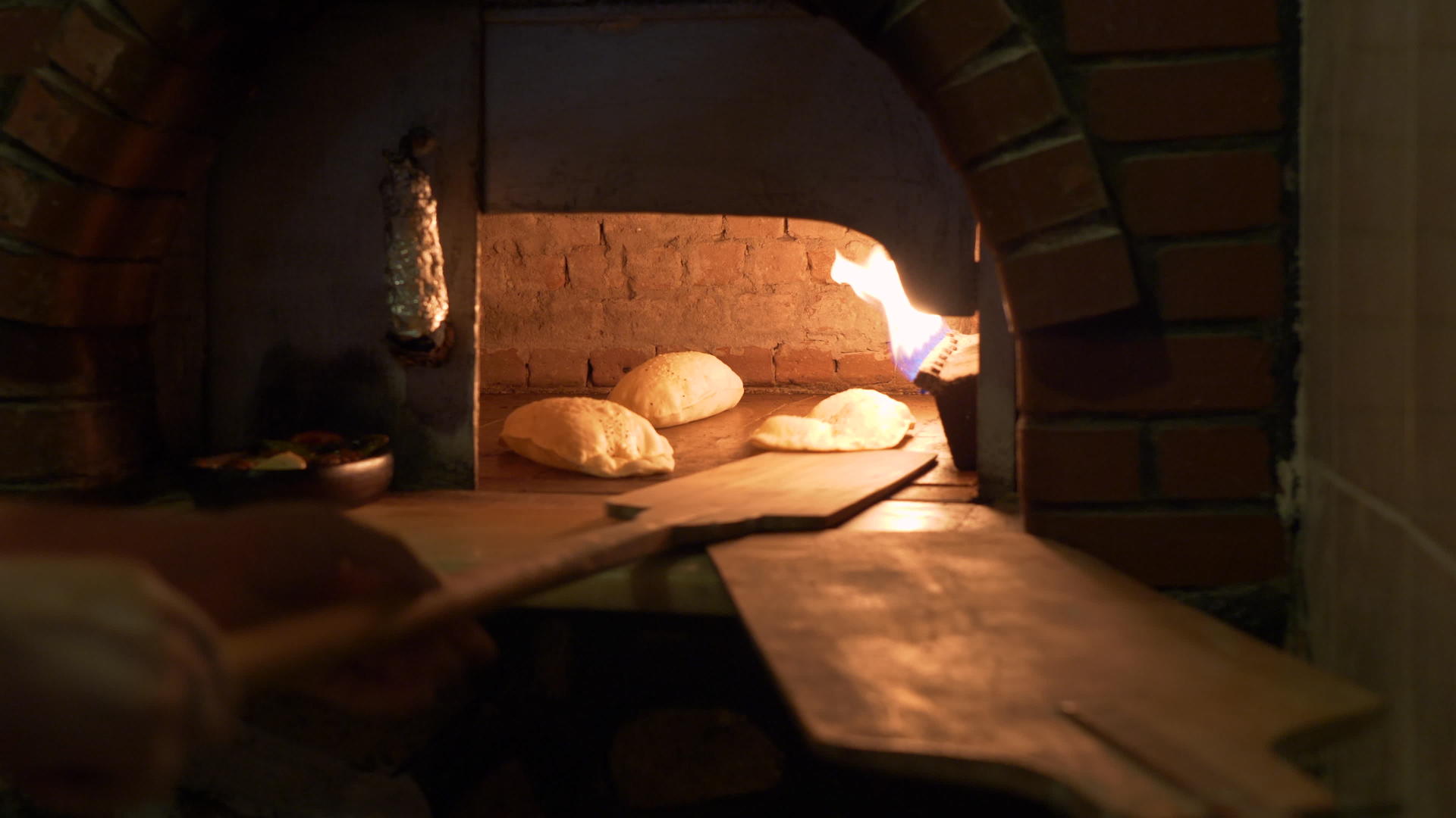 面包师在烤箱里用火焰和面包做面包视频的预览图