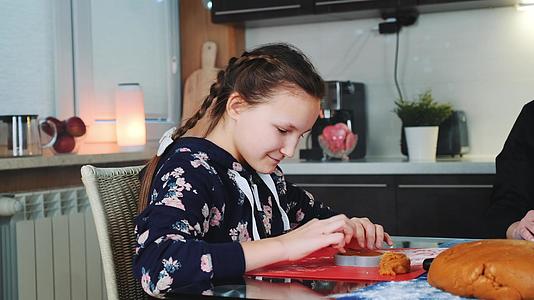 微笑的女孩帮助她妈妈做姜饼饼干视频的预览图