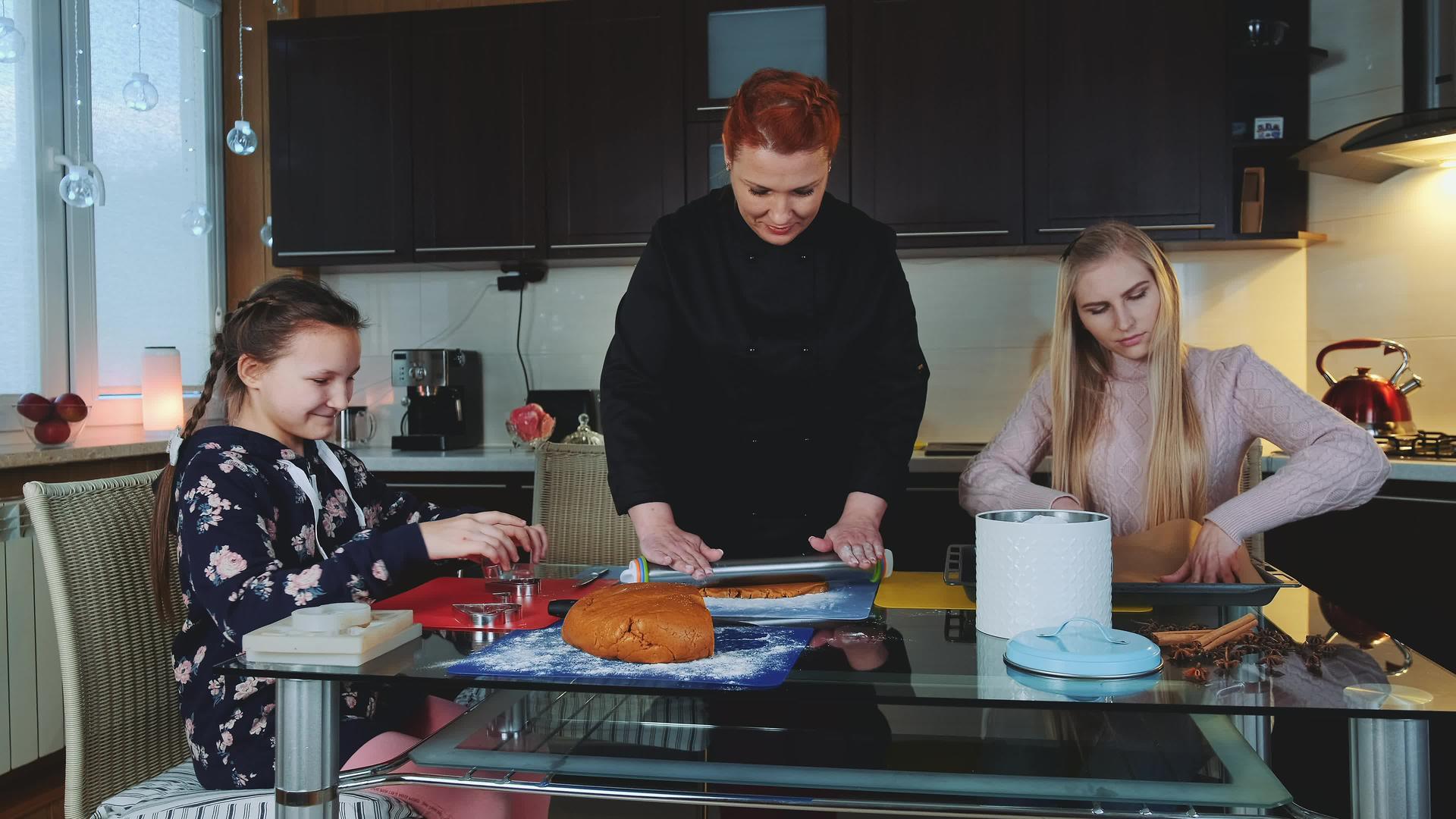 两名妇女和年轻女孩在厨房准备烤饼干视频的预览图