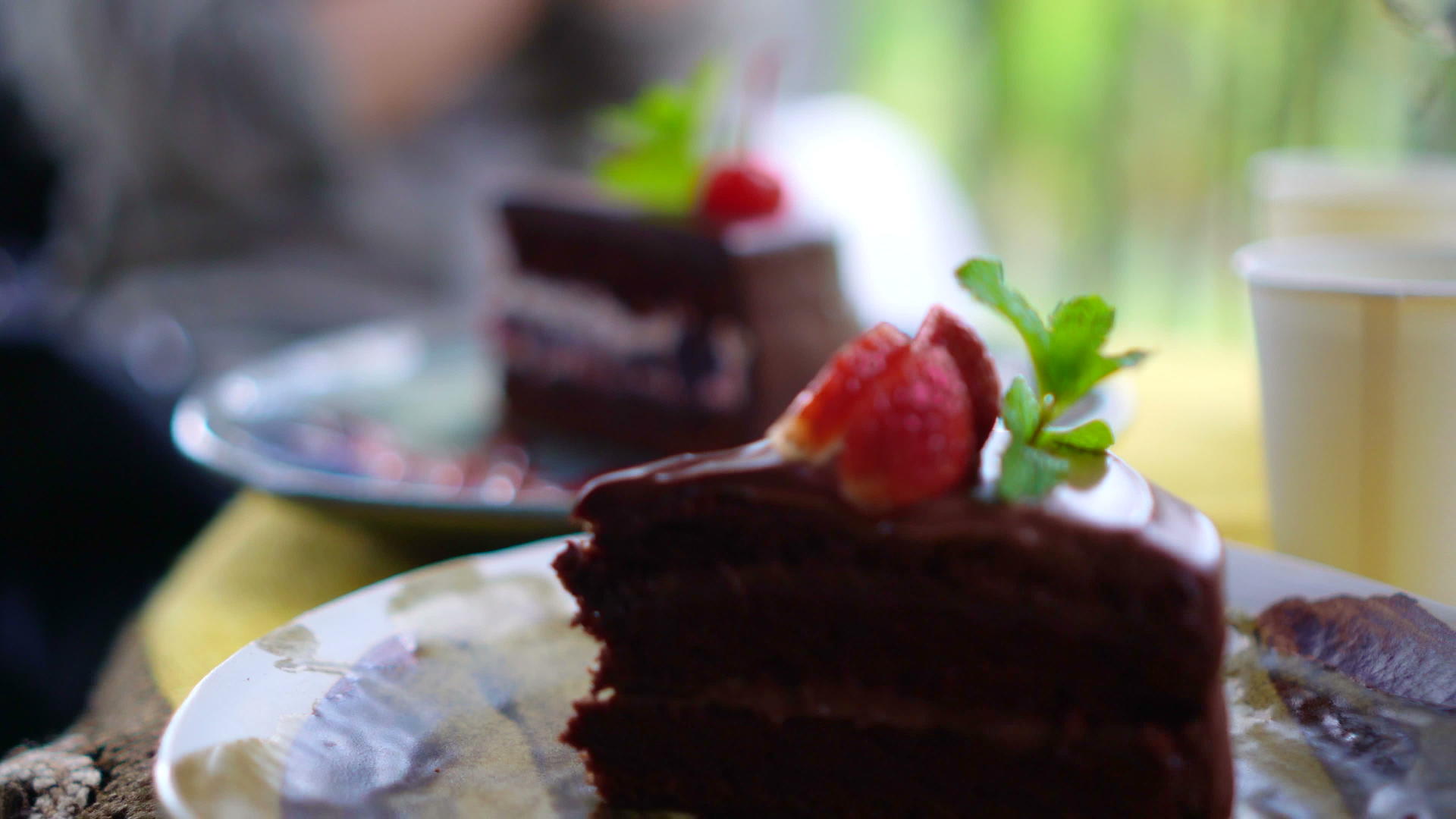 咖啡馆里有樱桃巧克力蛋糕聚焦前景4k视频的预览图