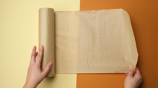 女性手持棕色背景的棕色纸卷视频的预览图