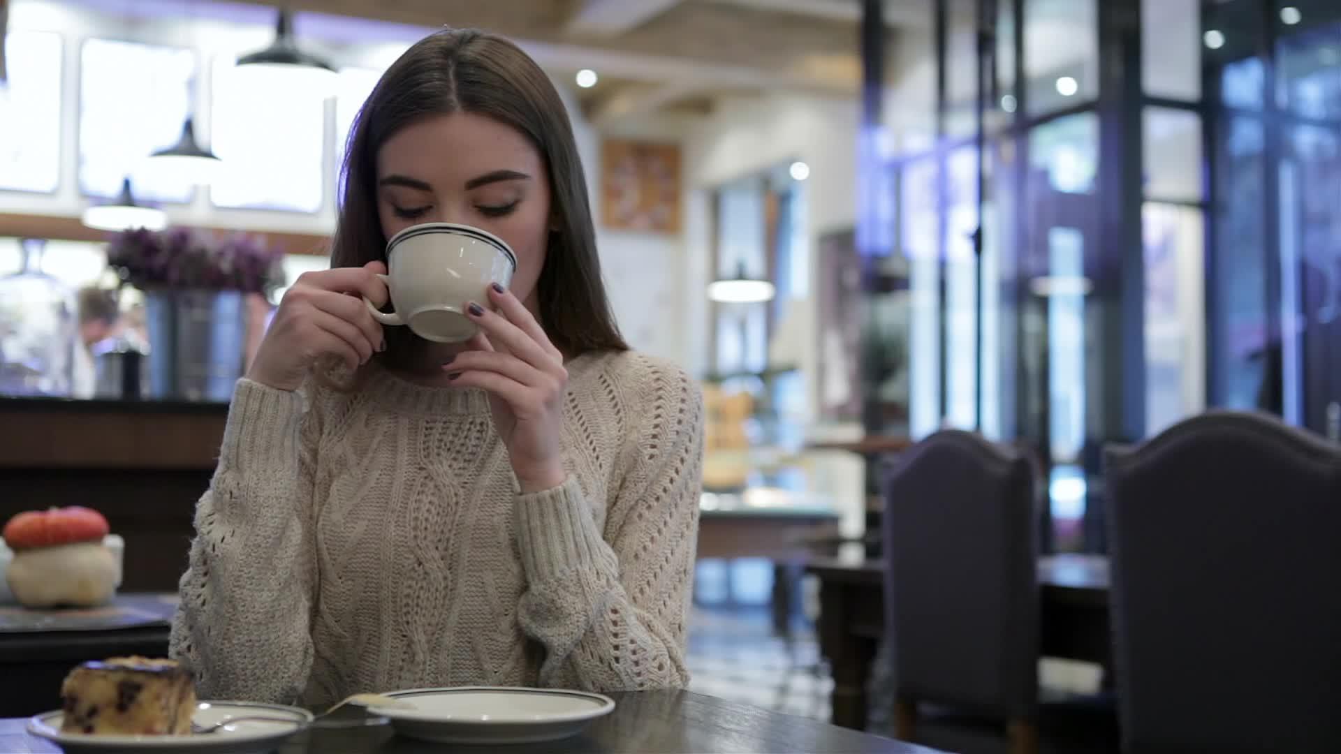 一个迷人的女孩喝了一杯咖啡视频的预览图