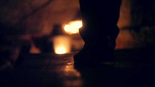 在蜡烛和灯笼的帮助下一个男人从黑暗中下楼视频的预览图