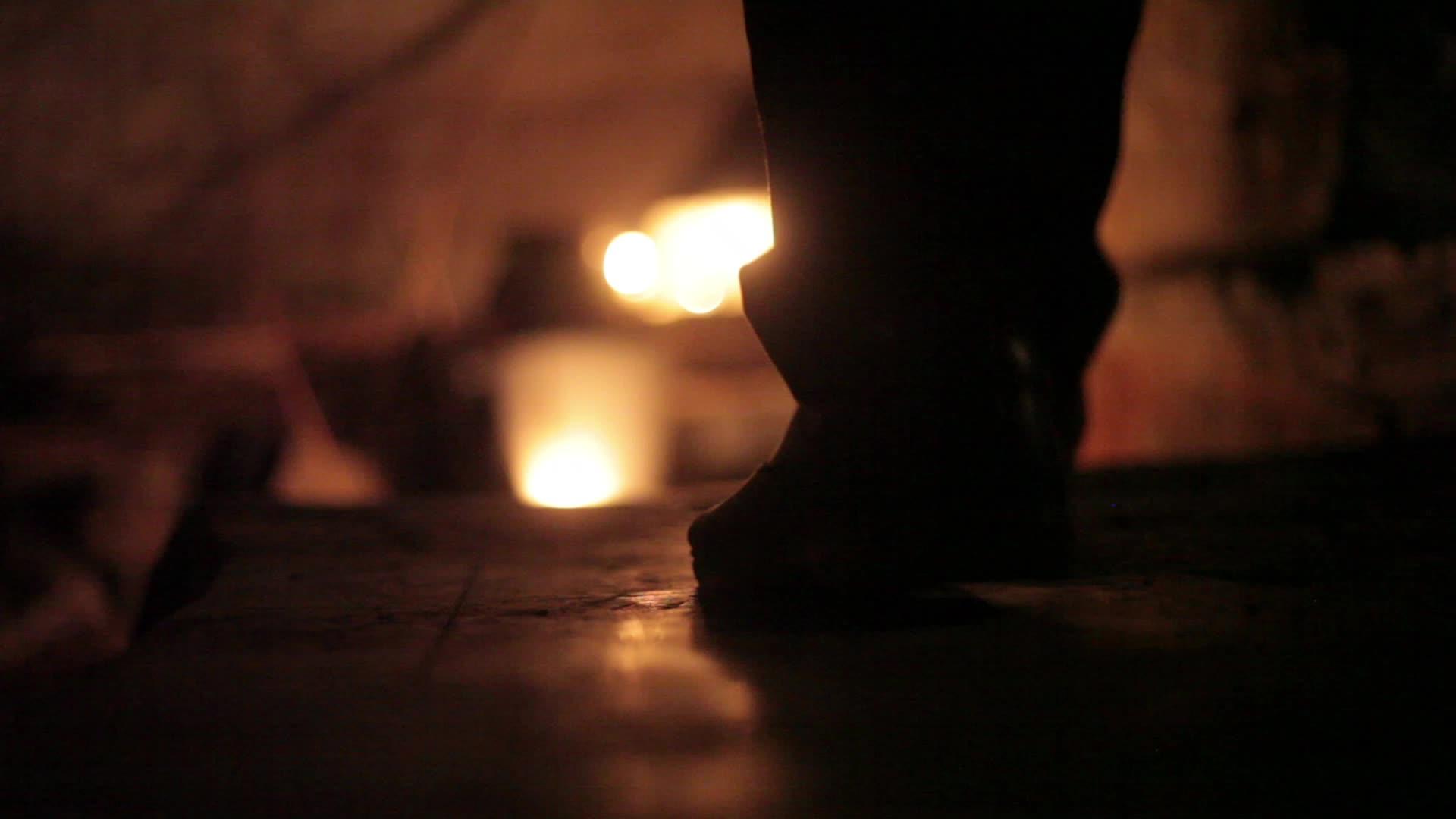 在蜡烛和灯笼的帮助下一个男人从黑暗中下楼视频的预览图
