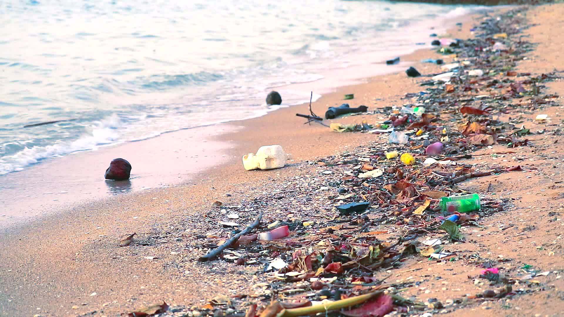 日落塑料橡胶和废物留在海滩上海浪把它们吹进海里视频的预览图