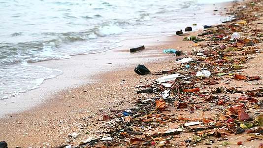 塑料橡胶和废物留在海滩上海滩上的日落浪把它们吹进海里视频的预览图
