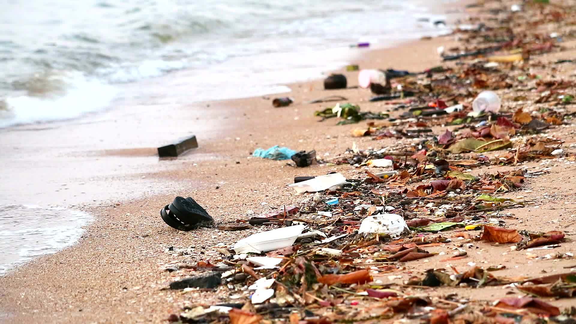 塑料橡胶和废物留在海滩上海滩上的日落浪把它们吹进海里视频的预览图