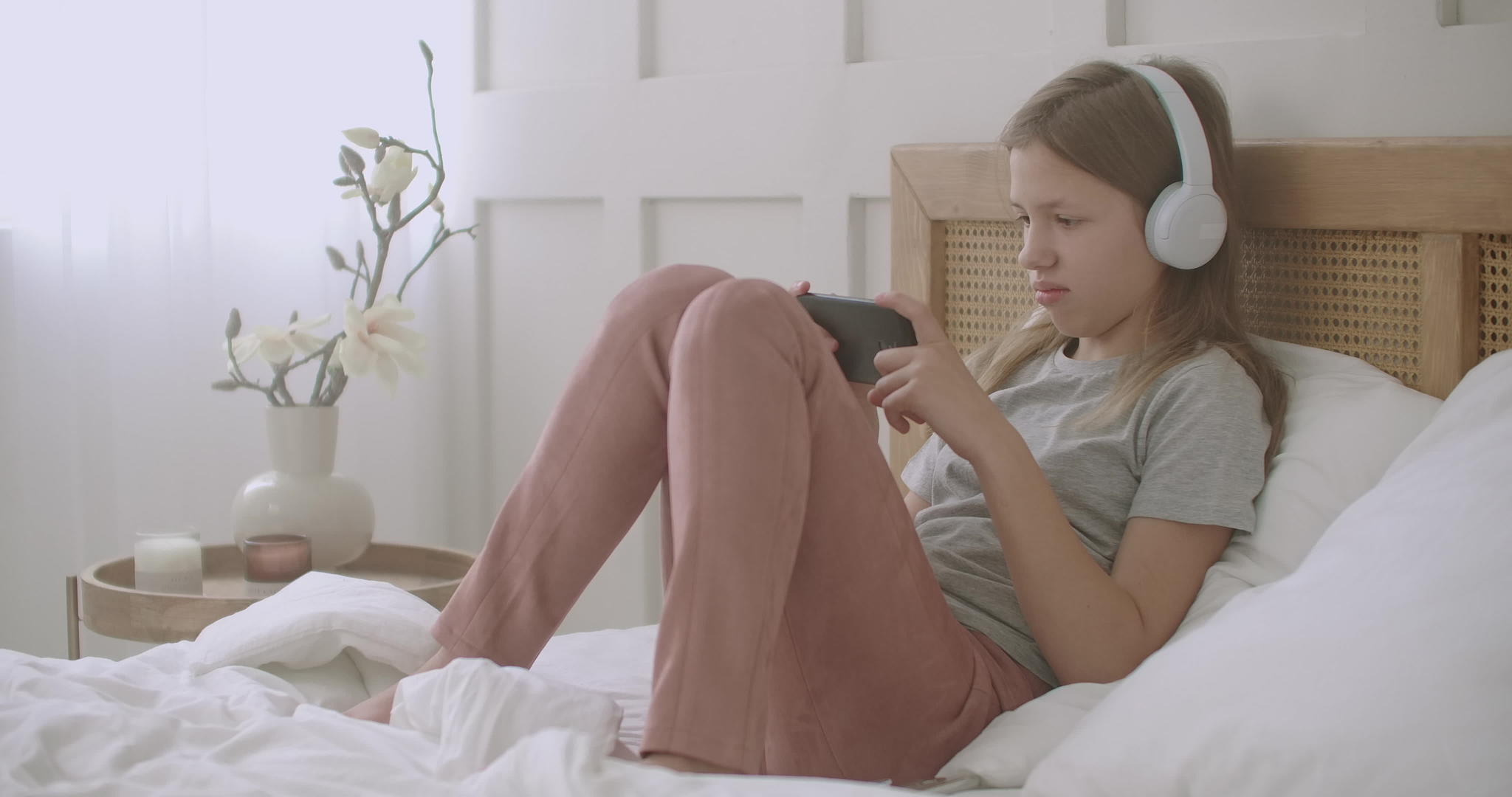 女孩音乐爱好者周末有空闲时间在卧室使用智能手机和智能手机视频的预览图