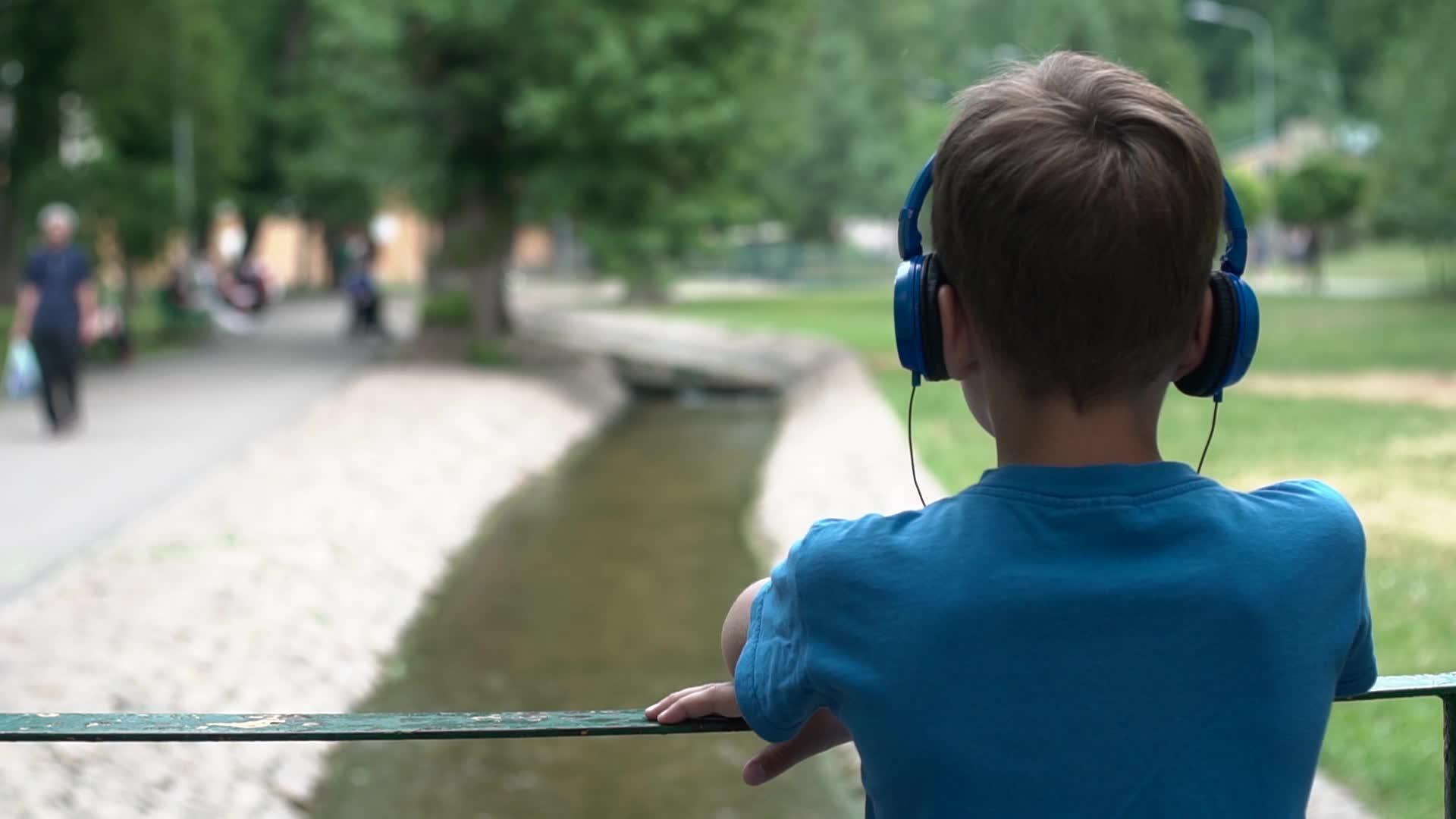 男孩用耳机听音乐视频的预览图