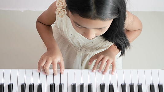 亚洲小女孩学会了在家里弹钢琴视频的预览图