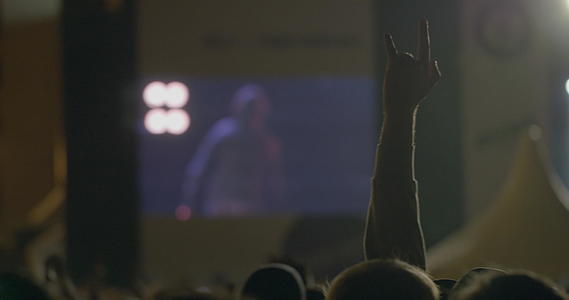 在户外音乐会的大屏幕前展示摇滚魔鬼角的风景人举手视频的预览图
