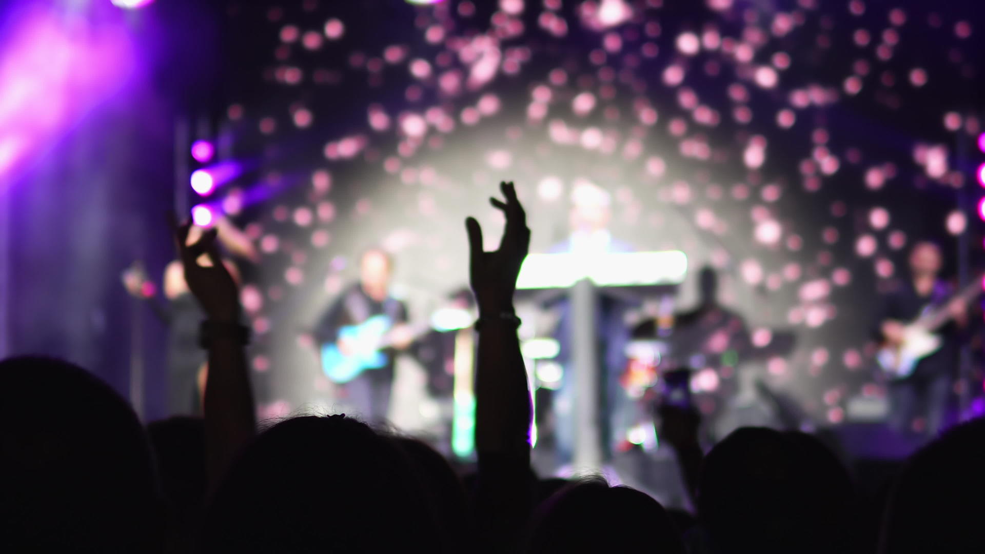 精力充沛的人在音乐会上举手跳舞有些人用手机表演视频的预览图
