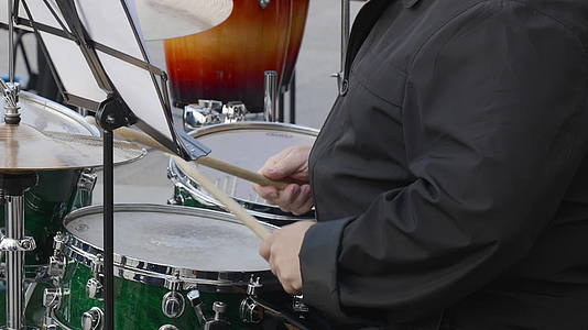 鼓手在户外鼓上演奏音乐在音乐会上用鼓槌演奏鼓视频的预览图