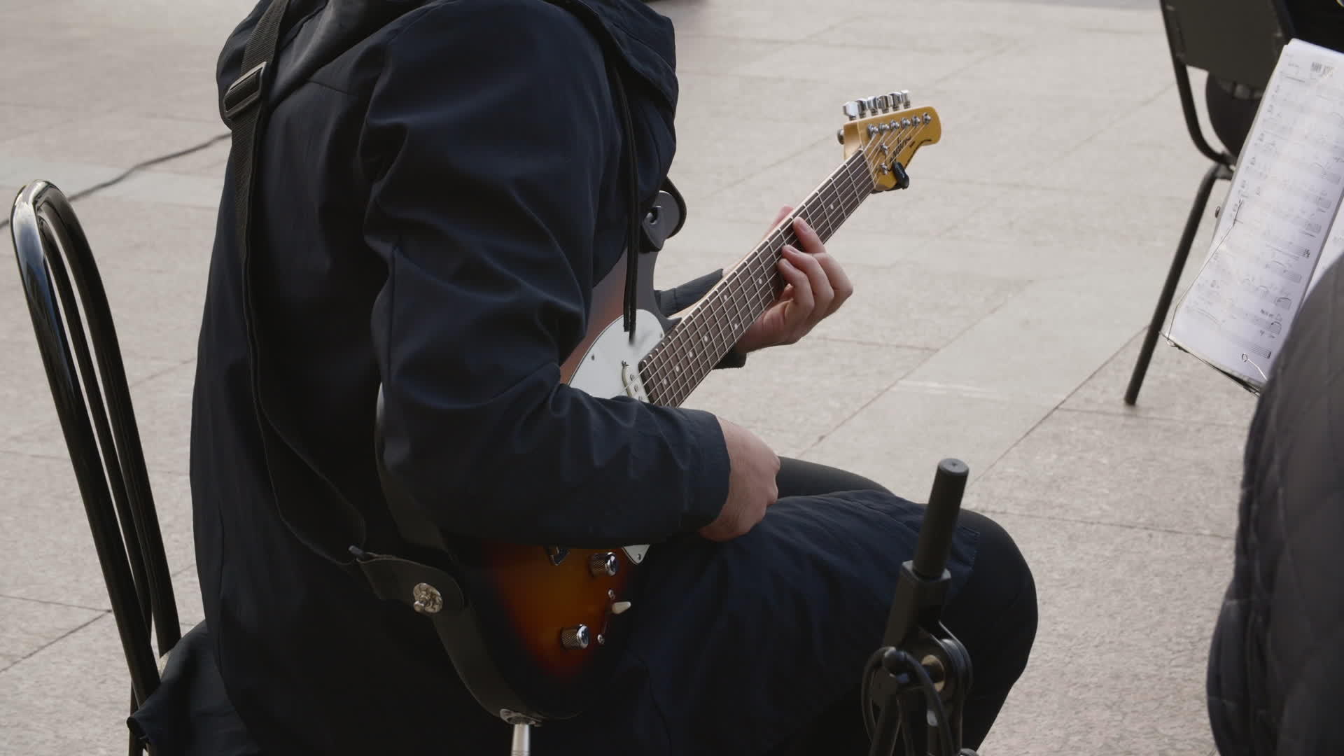 吉他手在户外表演中表演摇滚音乐家在街头音乐会上使用视频的预览图
