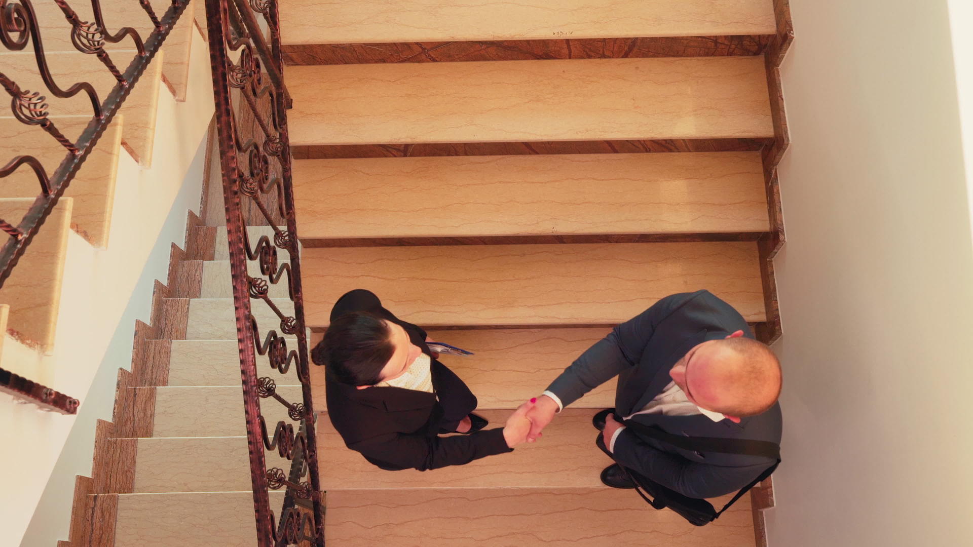 在楼梯上相遇的伙伴们在顶部的风景中握手视频的预览图
