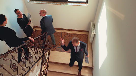 商业同事一起爬下楼梯的顶层视频的预览图