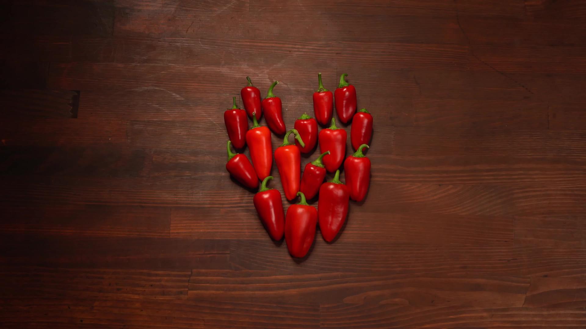 红色小胡椒的心脏暴露在木纹身板上k片段高品质视频的预览图