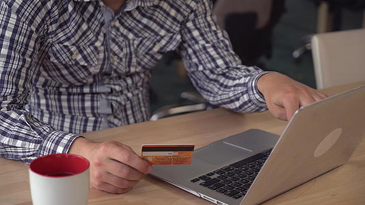 男性使用信用卡和电脑通过互联网购买信用卡和电脑视频的预览图