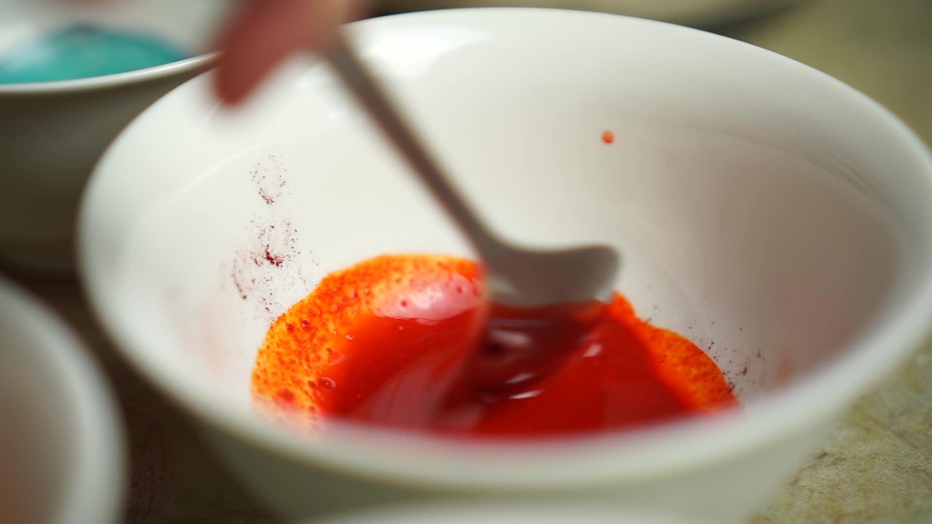 勺子在白碗板上搅拌红漆粉东方鸡蛋画画视频的预览图