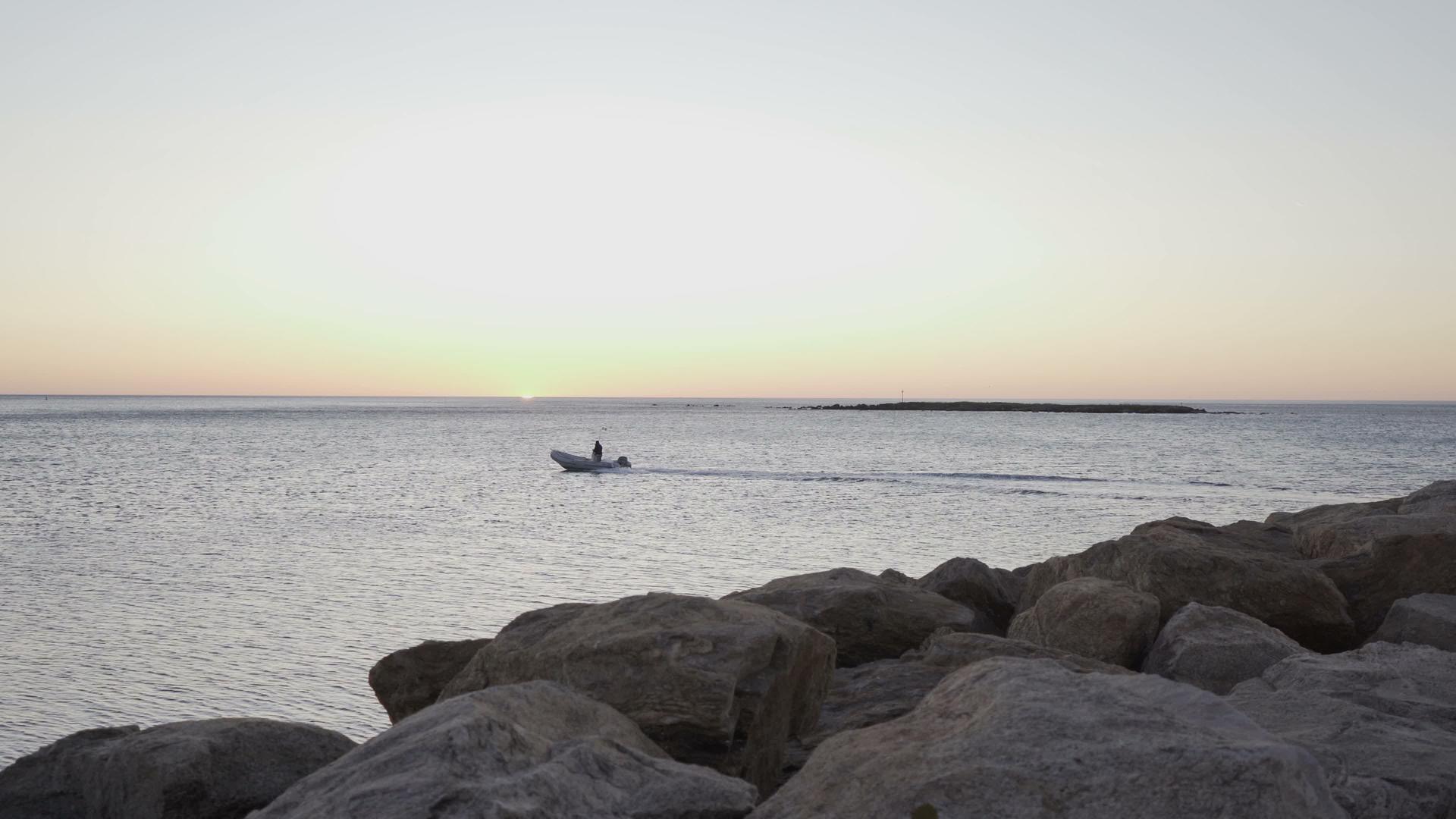 渔船在日出或日落时离开小港口视频的预览图
