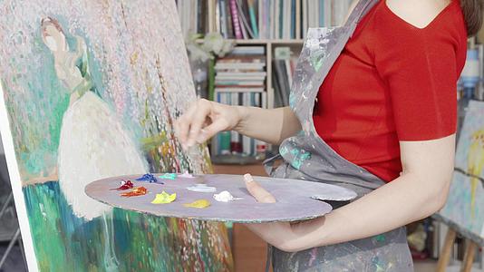 一位女艺术家在画画时在调色板上画画视频的预览图