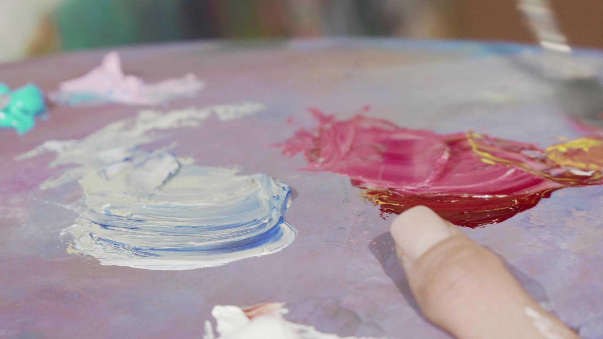 女艺术家在调色板上混合油漆视频的预览图