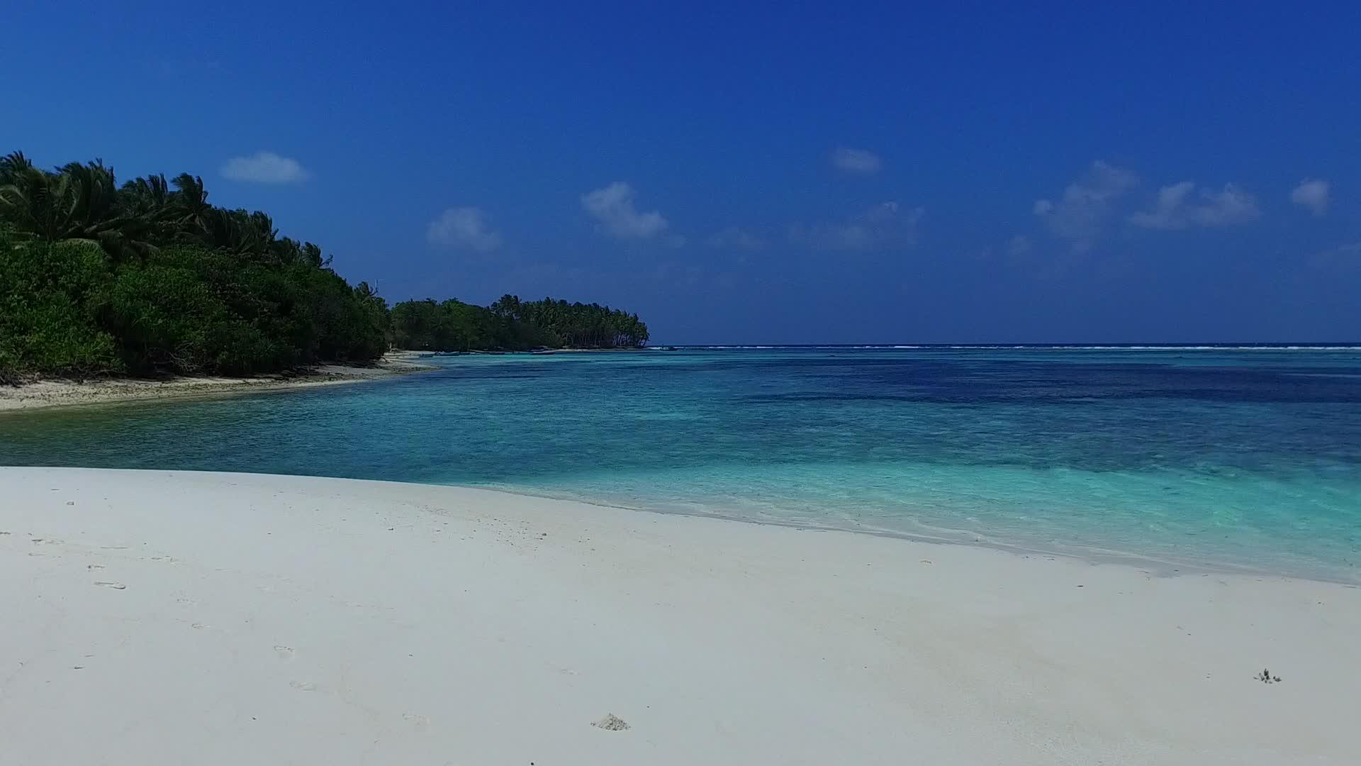 海浪附近的松松海岸航行由绿色珊瑚环礁湖和白色沙滩组成视频的预览图