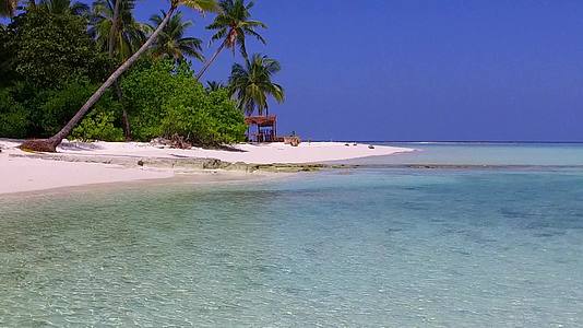 沿着浅海航行的开放岛屿海滩上有浪漫的棕榈树视频的预览图