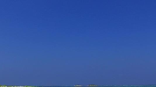 在蓝绿色的水和阳光下白色的绿色浅滩在白色的沙滩上是完美的光谱视频的预览图