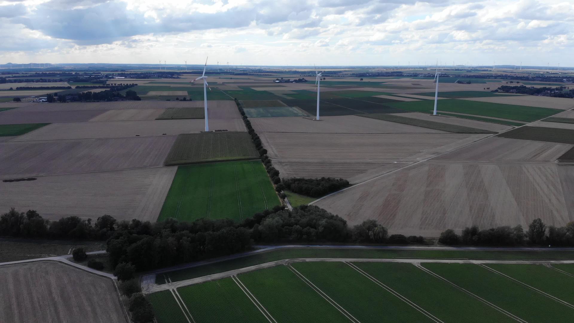 风车农场的鸟瞰图用于在高地美丽多云的天空中生产能源视频的预览图