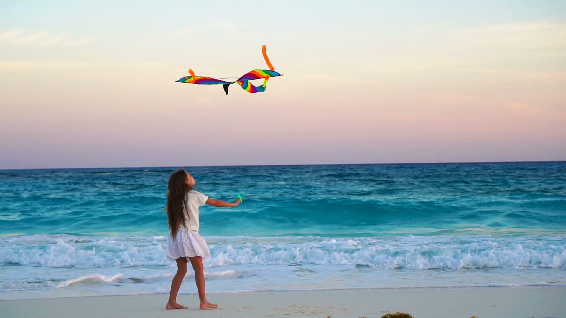 可爱的小女孩在热带海滩上放风筝快乐的孩子们在海边玩耍视频的预览图