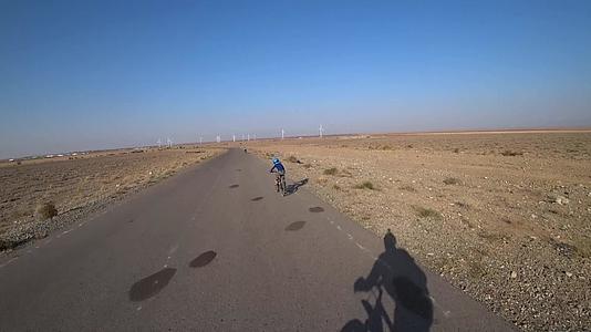 骑自行车的人在路上看到风车视频的预览图
