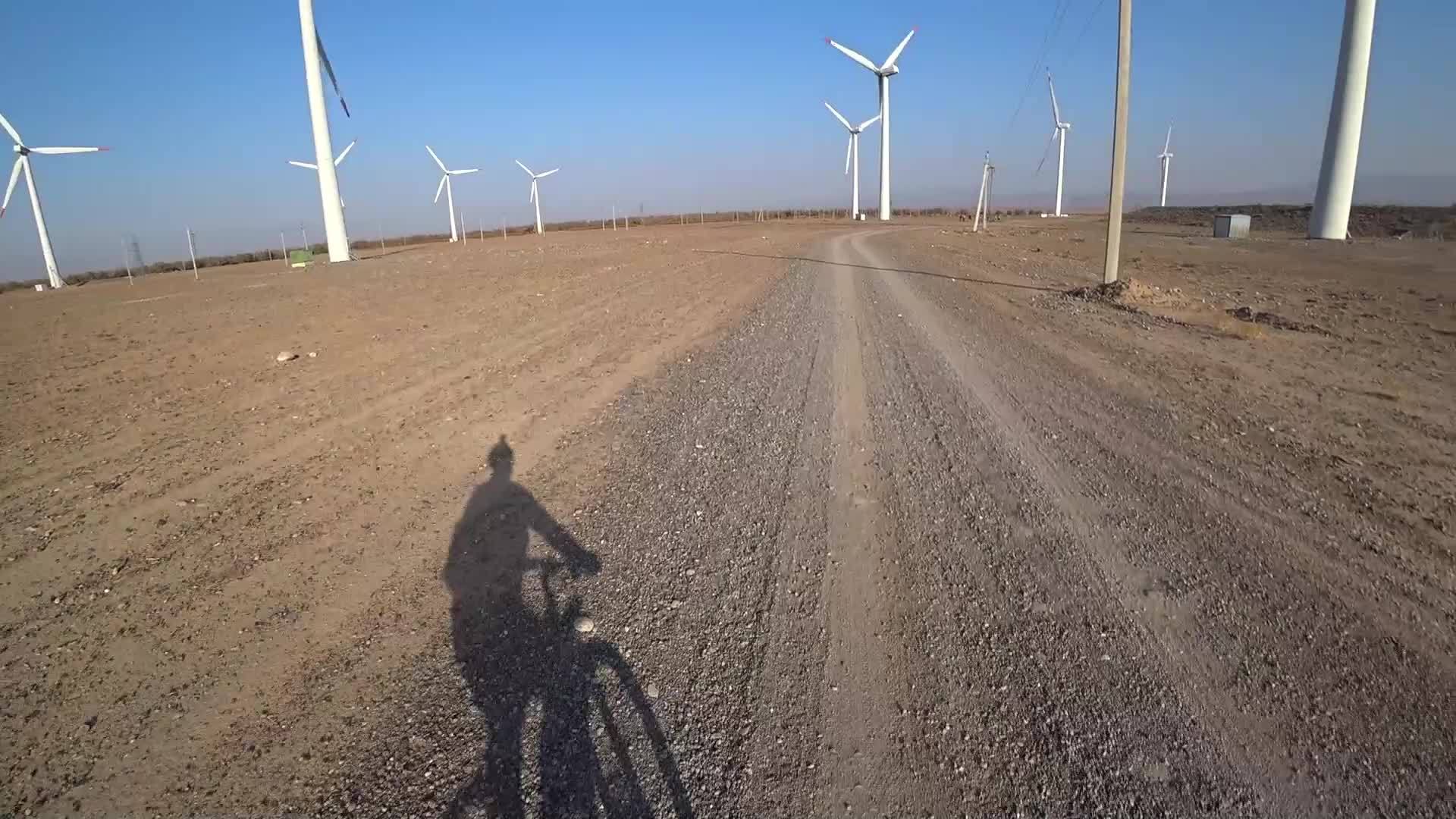 骑自行车的人在路上看到风车视频的预览图