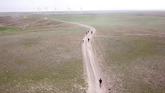 一群骑自行车的人沿着风车行驶视频的预览图