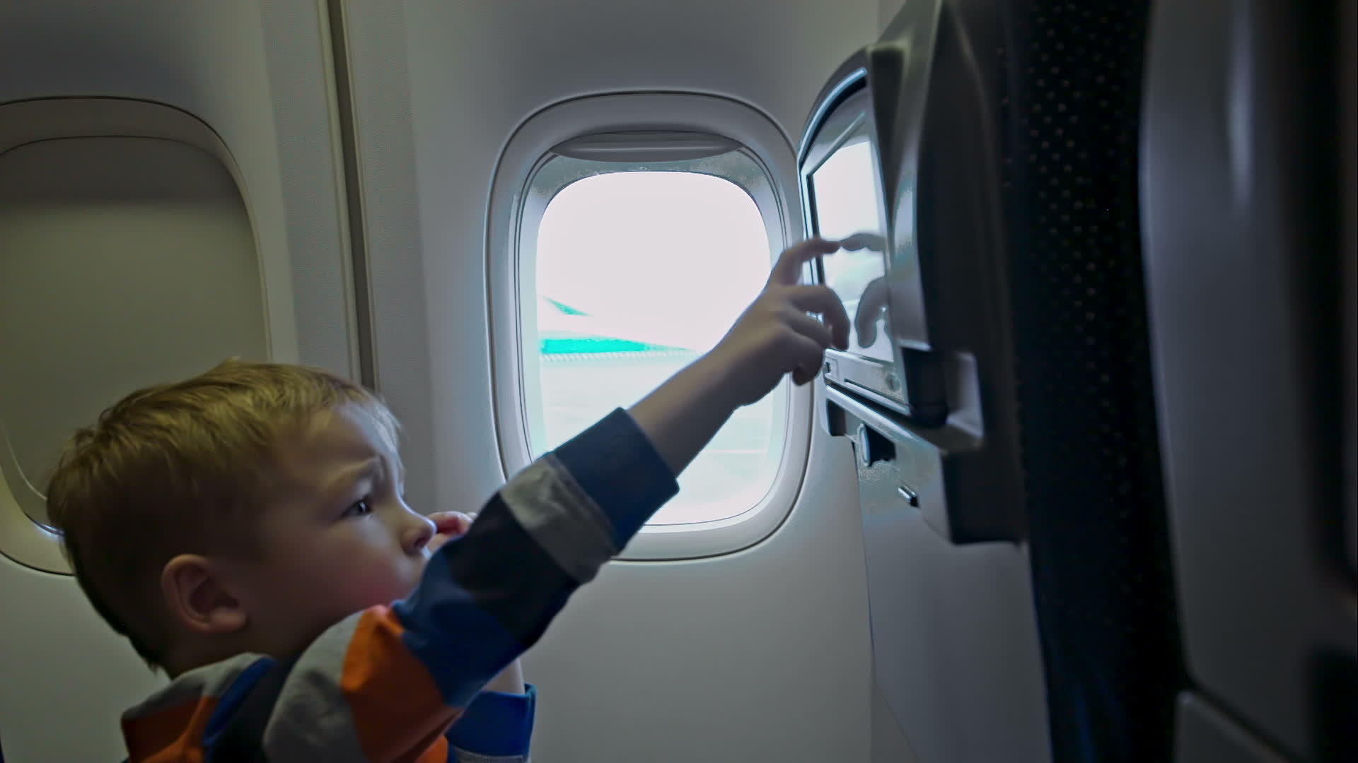 小男孩在飞机上触摸了座位监视器视频的预览图