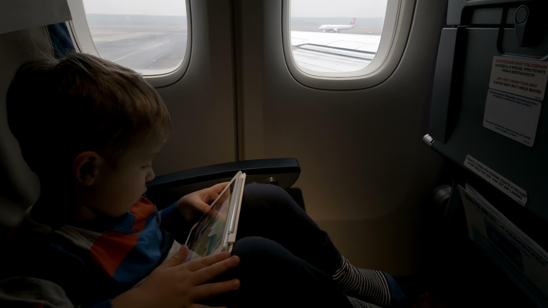 男孩在飞机上使用平板电脑pc起飞视频的预览图