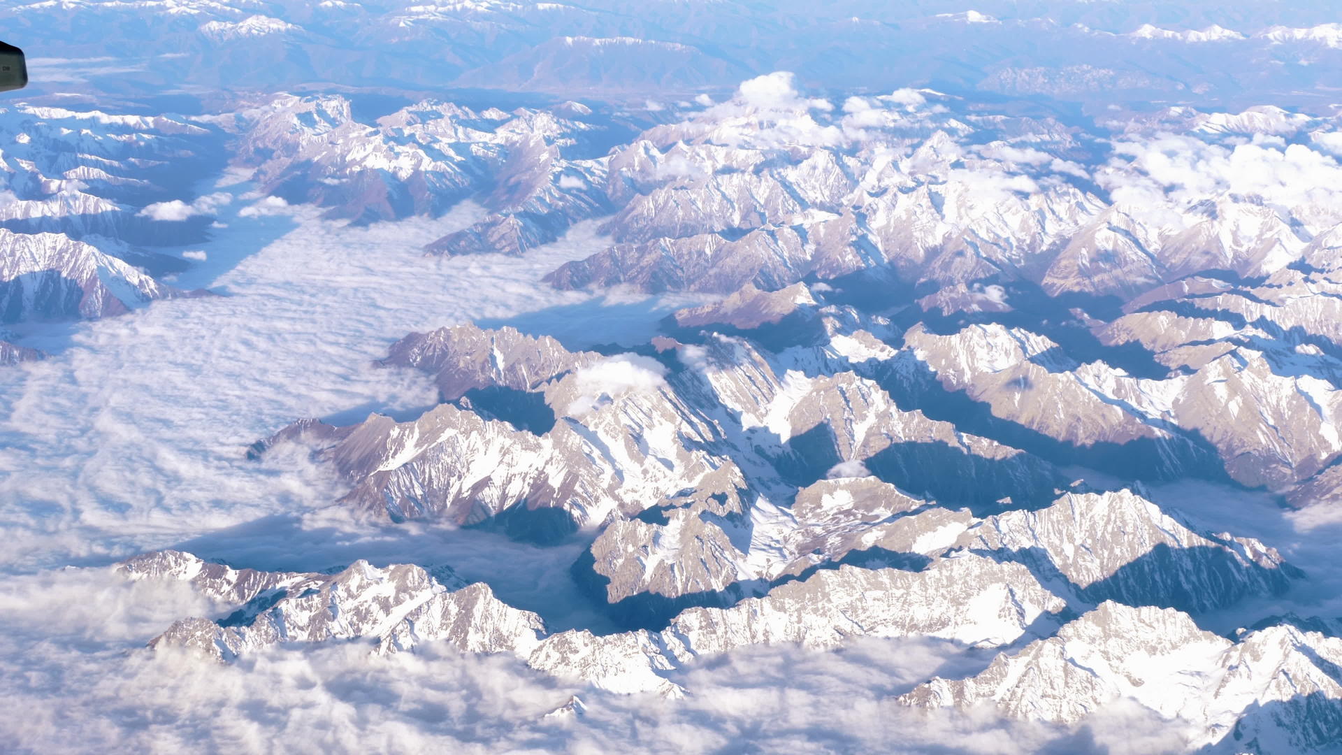美丽的风景穿过飞机窗口飞机在山上飞翔云彩飘扬视频的预览图