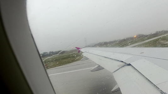 当飞机在暴风雨中从机场起飞时机翼窗口看到时间的折叠视频的预览图