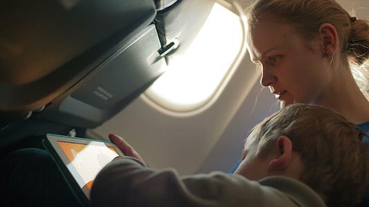 母亲和儿子在飞机上有触摸板视频的预览图