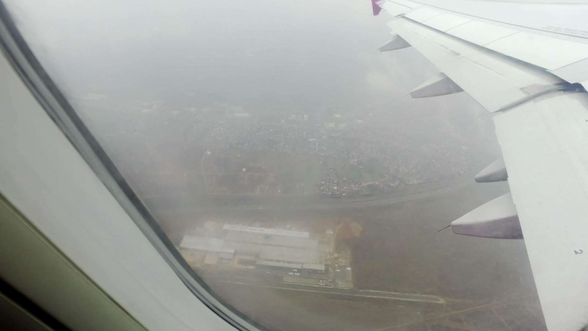 机载飞机飞机在雨天飞越城镇工厂视频的预览图
