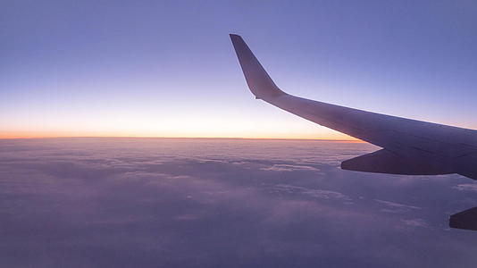 日落时从飞机窗口飞过云层视频的预览图