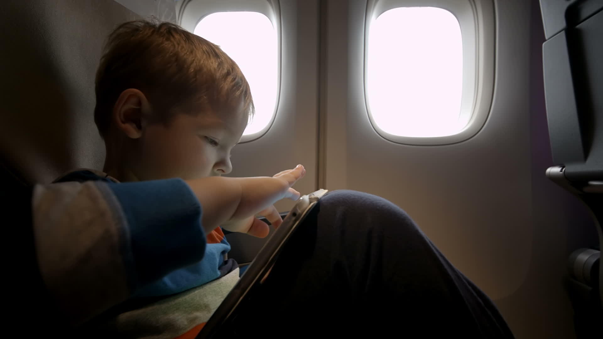 小男孩在飞机上的触摸垫上玩耍视频的预览图