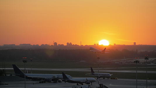 机场看到飞机在金色的日落时起飞视频的预览图