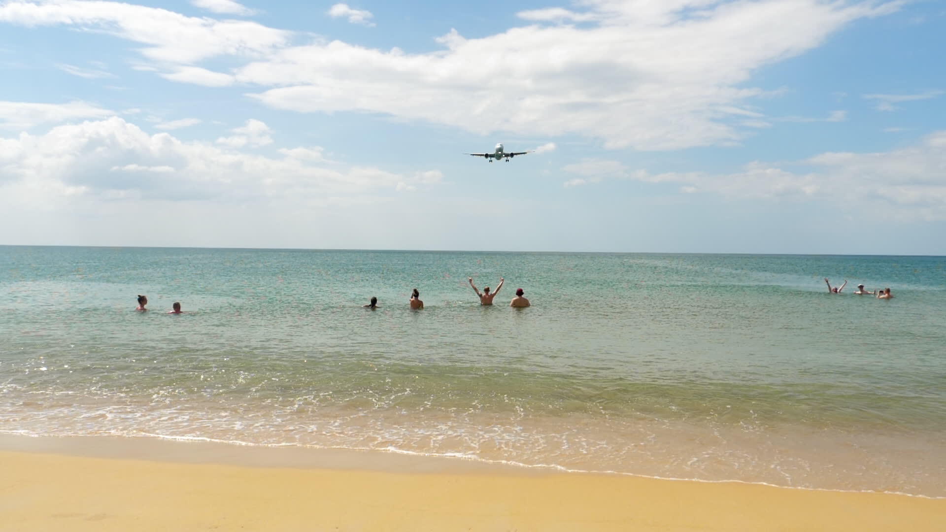 人们在海里游泳看着客机降落在普吉机场视频的预览图