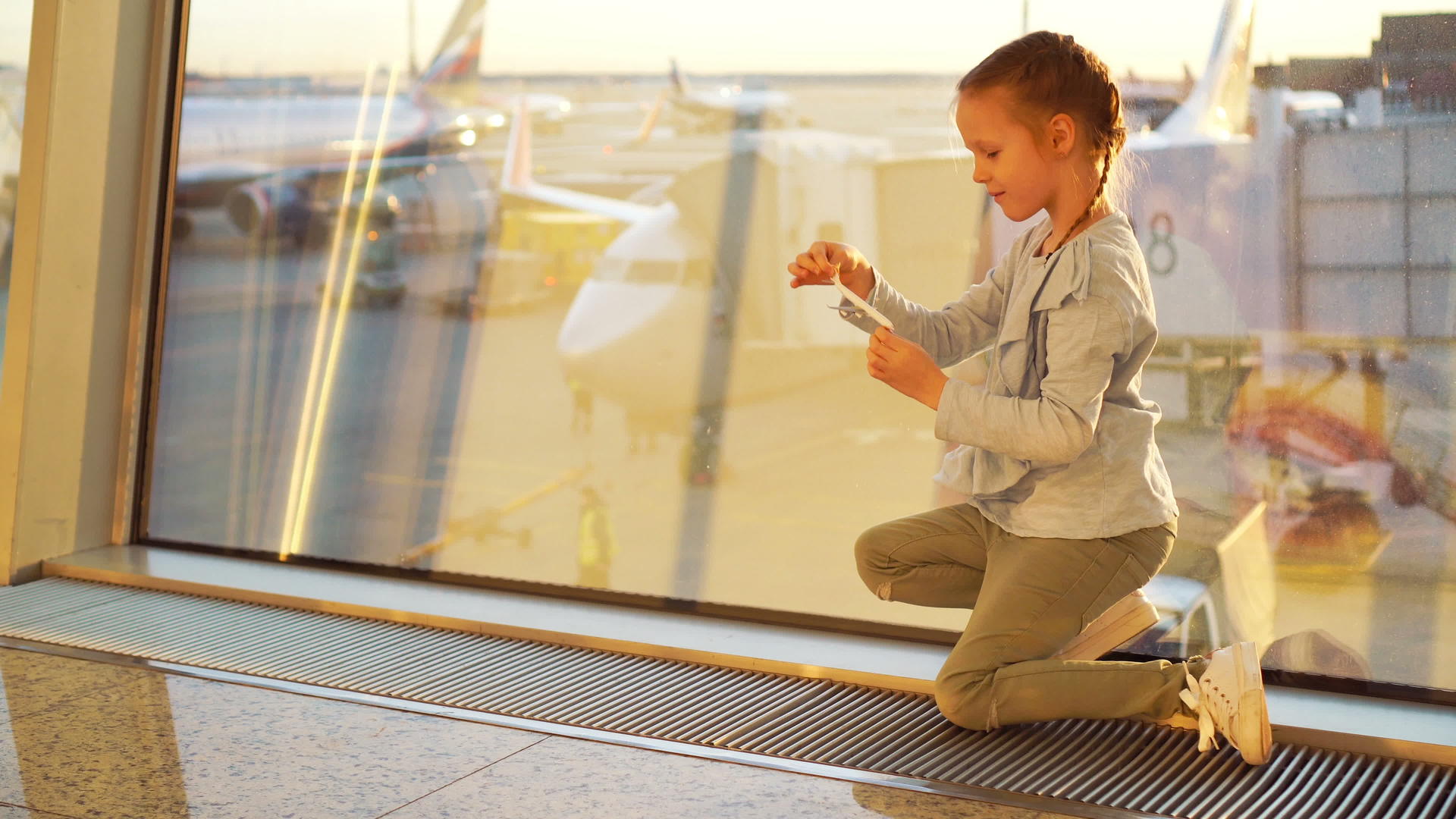 可爱的小女孩在机场等着登机玩小型飞机飞行和飞机飞行视频的预览图