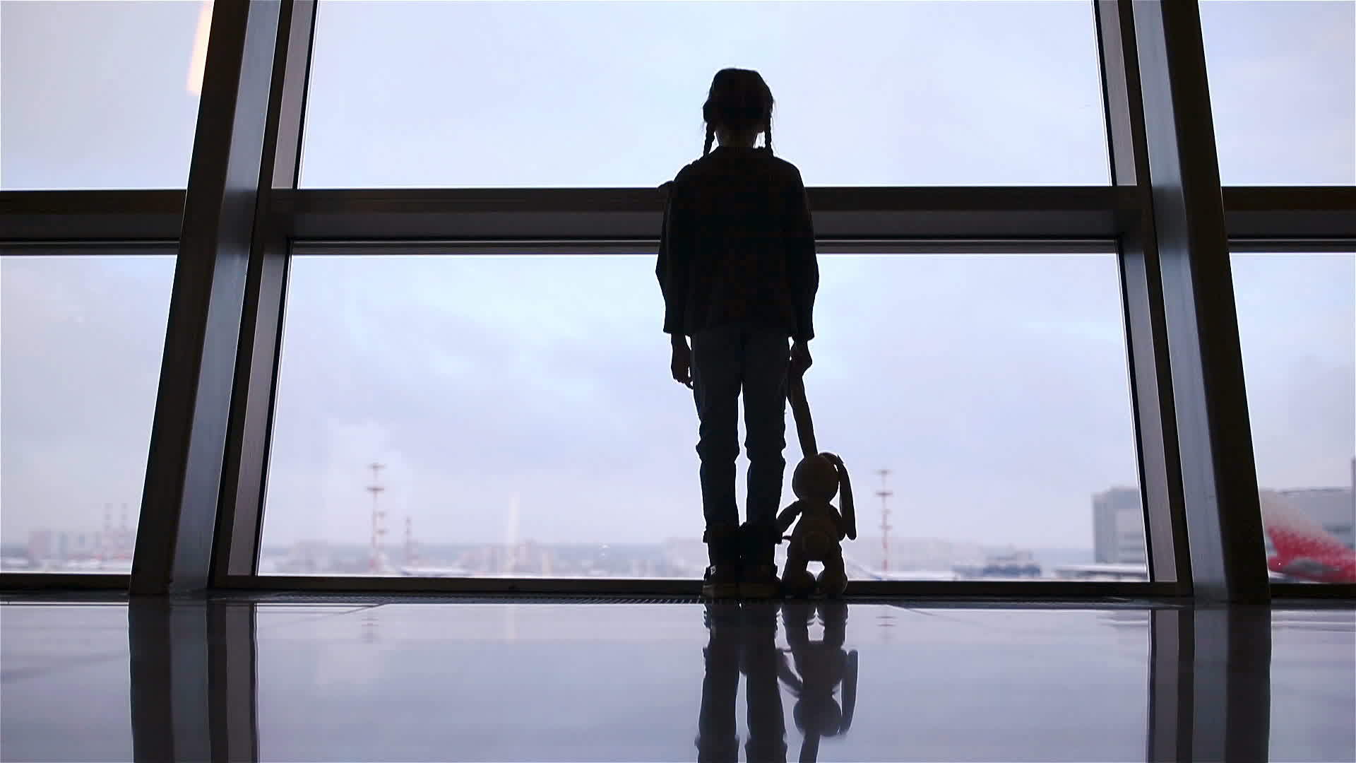 在等待登机时机场大窗附近的小女孩正在等待登机视频的预览图