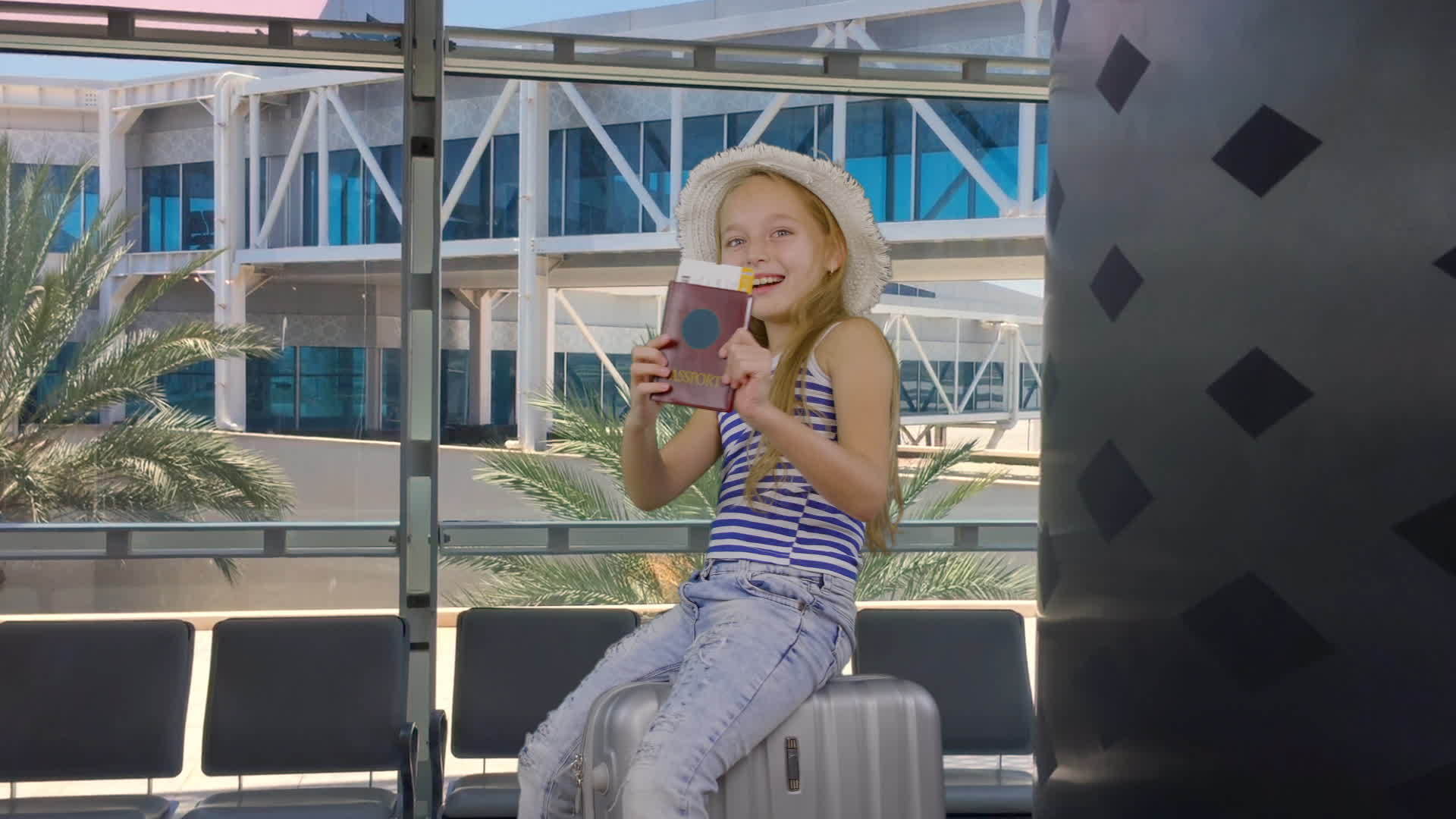 快乐的旅行者坐在机场的手提箱上带着护照和机票视频的预览图