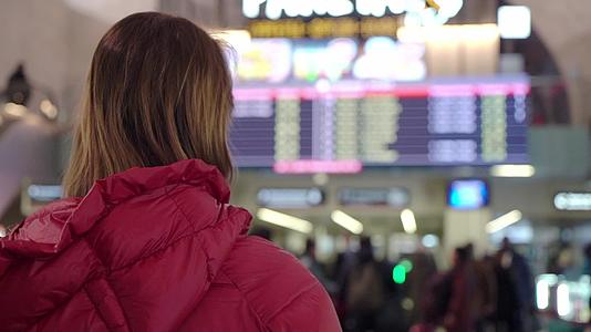 美丽的年轻旅游女青年在国际机场或火车站附近的飞行信息板视频的预览图